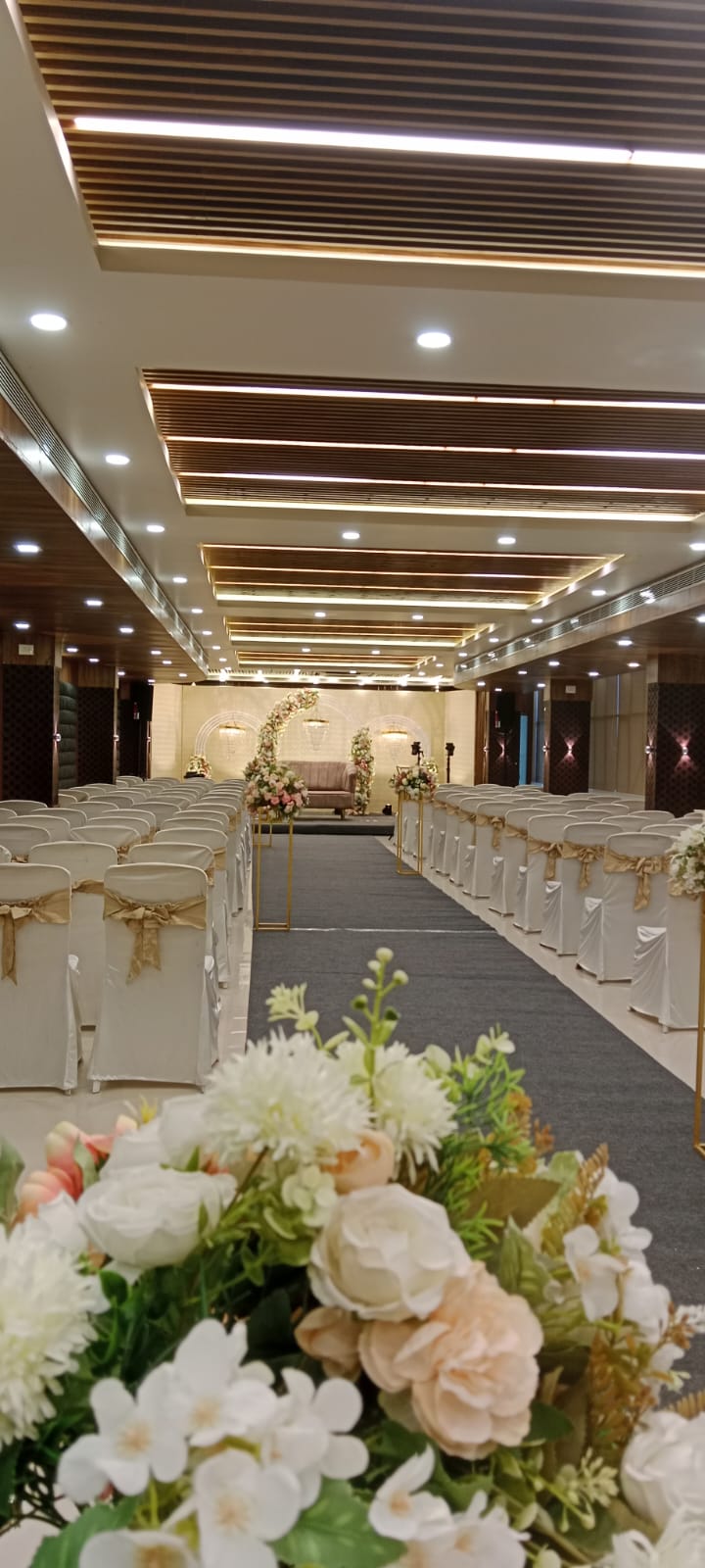 Wedding aisle with floral decor and sofa stage at the far end